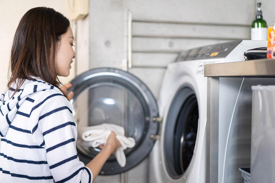 A woman using a drum-type washing machine